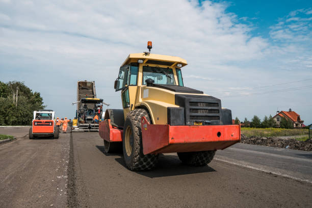 istock Yellow Red Heavy Vibration roller compactor at asphalt pavement works for road repairing. Working on the new road construction site. Repairing. 1022176156