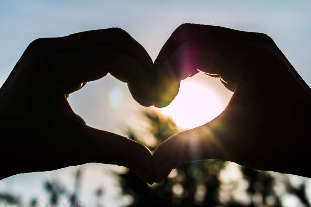 istock love shape hand silhouette at sunset 1022182112