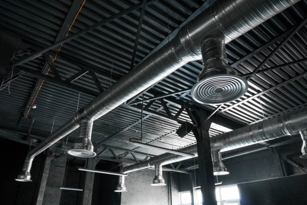 Ventilation system on the ceiling of large buildings. Ventilation pipes in silver insulation material hanging from the ceiling inside new building. stock photo