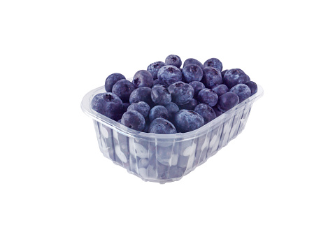 Ripe purple blueberries in the plastic container isolated on white. Berries packed for supermarket.