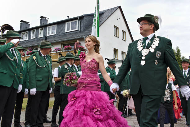 The winner of the shooting competition parades past the ranks of his saluting fellow club members in their traditional green uniforms with his wife at the marksmen's fair stock photo