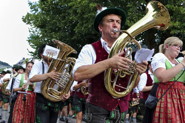 Bavarian marching band in traditional dress playing brass instruments at a parade stock photo