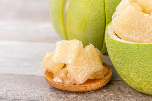 istock fresh and peeled pomelo(shaddock), grapefruit with slices on wooden table background 1022216242