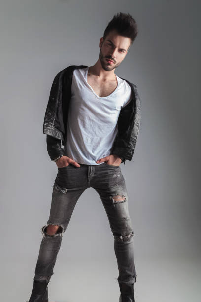 istock sexy man in leather jacket stands with hands in pockets 1022216272
