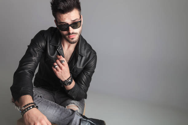 istock seated man wearing sunglasses and leather jacket looks to side 1022216420