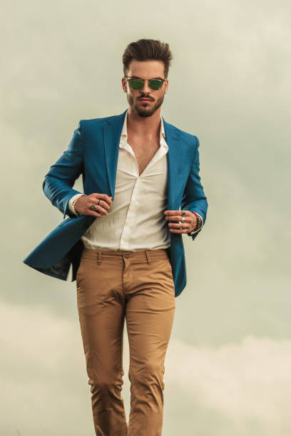 istock sexy man holding blue suit walking on clouds background 1022229044