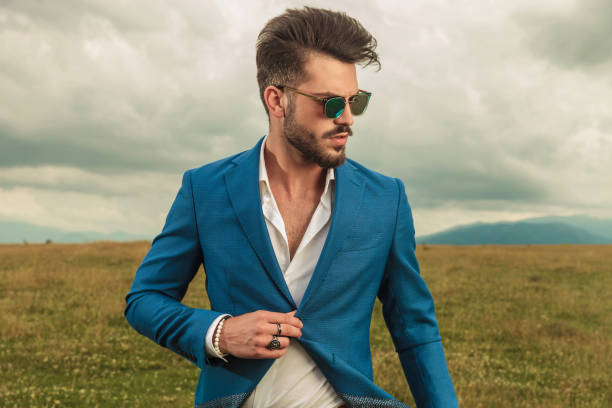 istock attractive smart casual man with sunglasses buttoning blue suit outside 1022233436