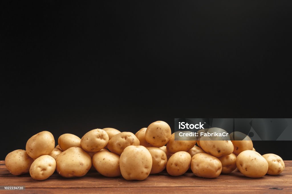 Pile of potatoes lying on wooden boards Prepared Potato Stock Photo