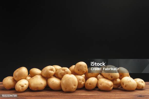 Pile Of Potatoes Lying On Wooden Boards Stock Photo - Download Image Now - Prepared Potato, Heap, Stack