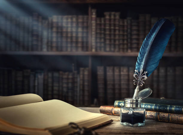 Conceptual background on history, education, literature topics. Old quill pen, books and vintage inkwell on wooden desk in the old office against the background of the bookcase and the rays of light. Retro style. Conceptual background on history, education, literature topics. author stock pictures, royalty-free photos & images