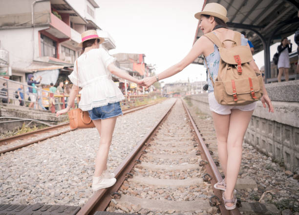 istock Women holding hands and walking along railway 1022236992