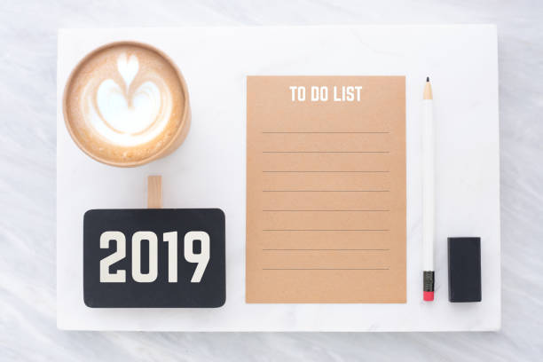 2019 to do list on brown recycle paper with pencil,clip blackboard,pencil,eraser and coffee cup on white and grey marble table.mock up for adding text,new year resolution concept. 2019 to do list on brown recycle paper with pencil,clip blackboard,pencil,eraser and coffee cup on white and grey marble table.mock up for adding text,new year resolution concept 2019 new year resolution stock pictures, royalty-free photos & images