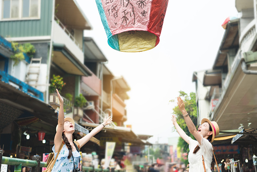 happy two girl release let go the sky lanterns to air. Translation on sky lanterns text 