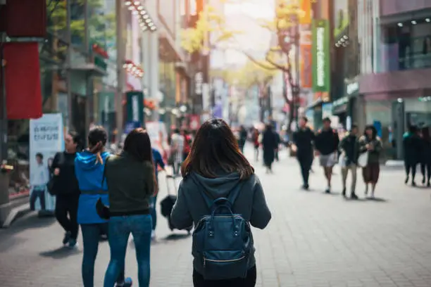 Young asian woman traveler traveling and shopping in Myeongdong street market at Seoul, South Korea. Myeong Dong district is the most popular shopping market at Seoul city.