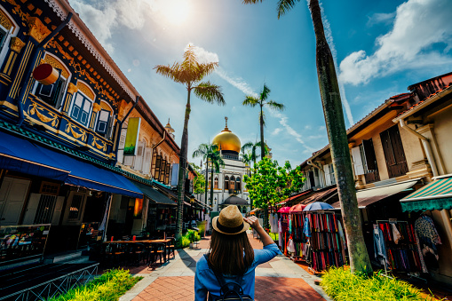 Young woman traveler traveling into The Masjid Sultan mosque located in Kampong Glam in Singapore city.