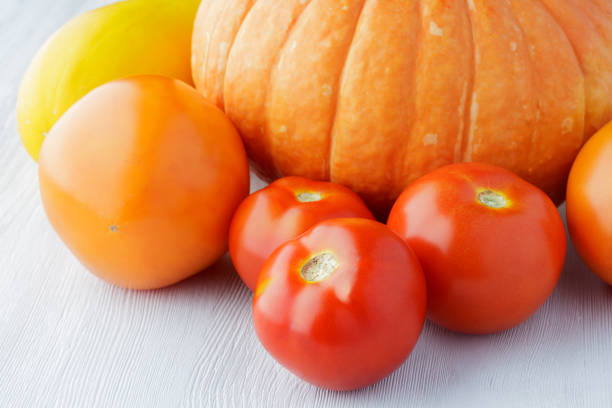 red and yellow tomatoes and pumpkins in the wooden box
