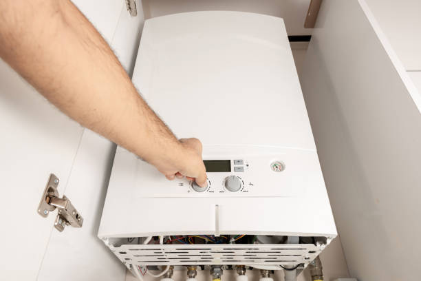 istock Man turning on a Combi Gas Boiler 1022249514