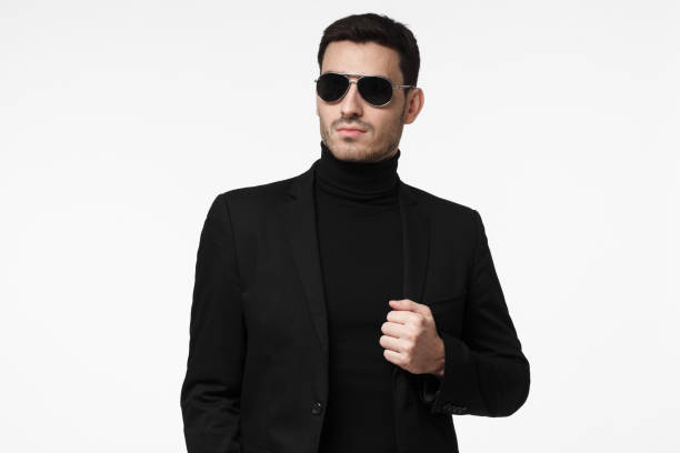 tough bodyguard or secret agent wearing suit and sunglasses, isolated on grey background - spy secrecy top secret mystery imagens e fotografias de stock