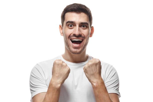 istock Young attractive man shouting when his team wins, raised both fists in victory gesture, isolated on white background 1022250174