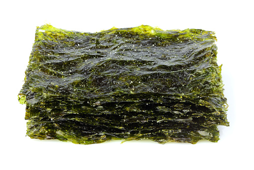 Crispy dried seaweed nori with salt isolated on white background.