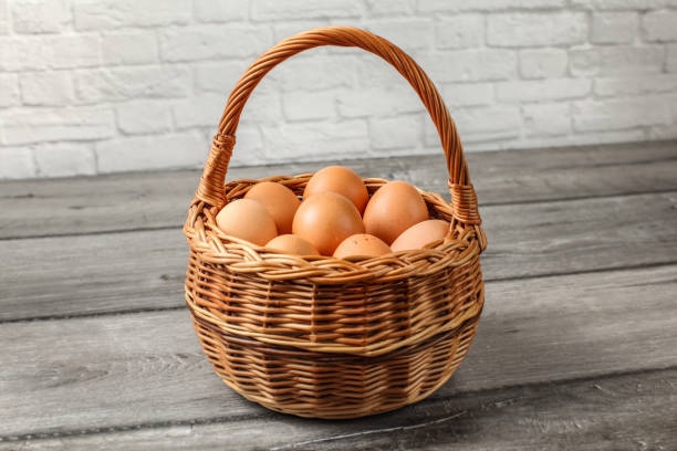 istock Eggs in wicker basket placed on gray wood desk by the wall. 1022263174