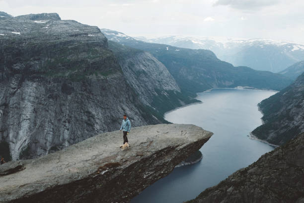 istock Man with dog enjoying scenic view from Trolltunga 1022269408