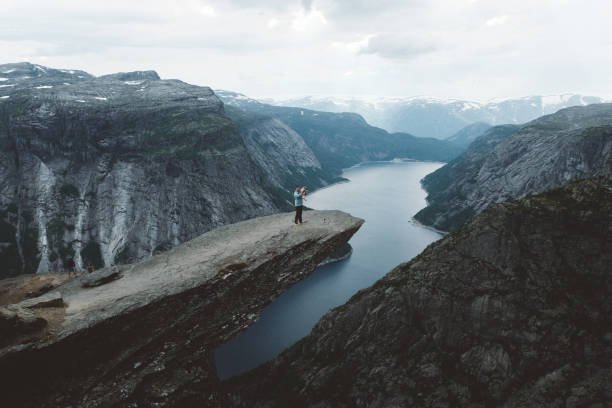 istock Man with dog enjoying scenic view from Trolltunga 1022269772
