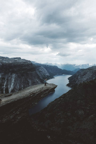 istock Man with dog enjoying scenic view from Trolltunga 1022271028