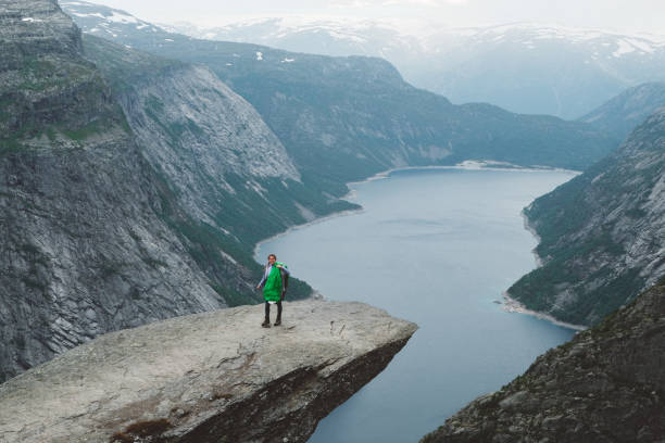 istock Happy woman with sleeping bag on Trolltunga 1022271660