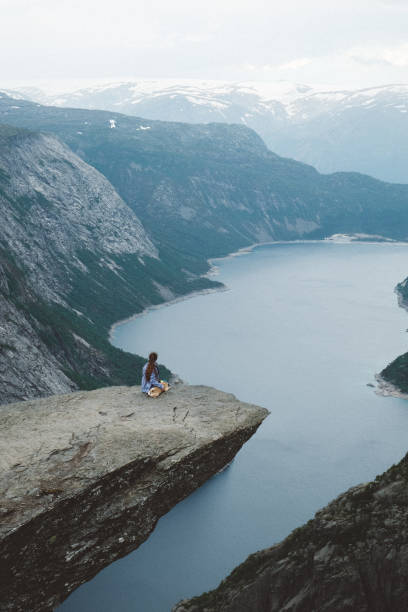 istock Woman with dog enjoying scenic view from Trolltunga 1022271664
