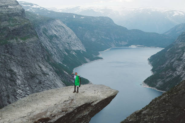 istock Happy woman with sleeping bag on Trolltunga 1022271998