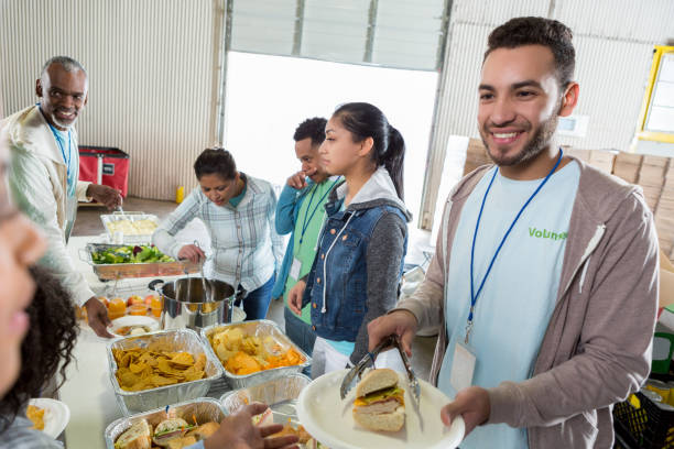 istock Young Hispanic man serves meal in soup kitchen 1022277602