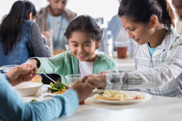 istock Family say grace together in soup kitchen 1022277662