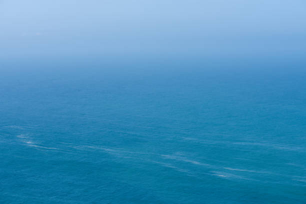 Aerial view of calm infinite ocean and blue sky background