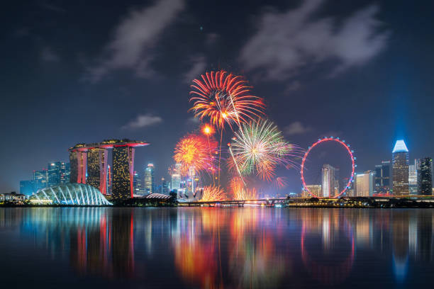 fuochi d'artificio della festa nazionale di singapore nel centro di singapore nella zona di marina bay di notte. distretto finanziario, ruota panoramica e grattacieli. - ferris wheel foto e immagini stock