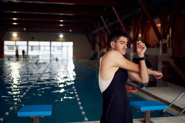 istock Young male swimmer strecthing before getting into the pool. 1022288834