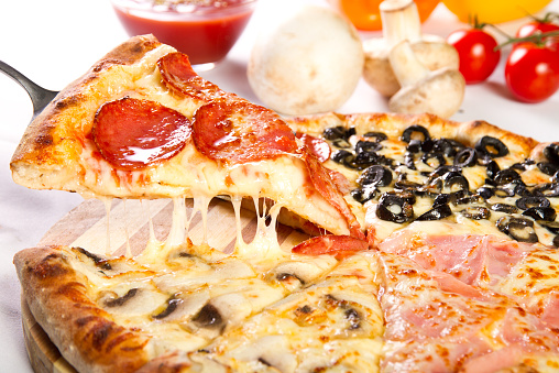 Pizza Quattro stagioni with salami, ham, olives and mushrooms