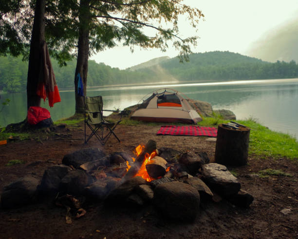Campfire outside of tent and campsite on a lake in the Adirondack Mountains. stock photo