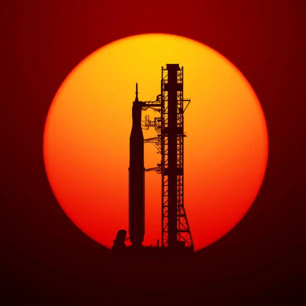 Space Launch System On Launchpad Over Background Of Red Sun. 3D Illustration.
