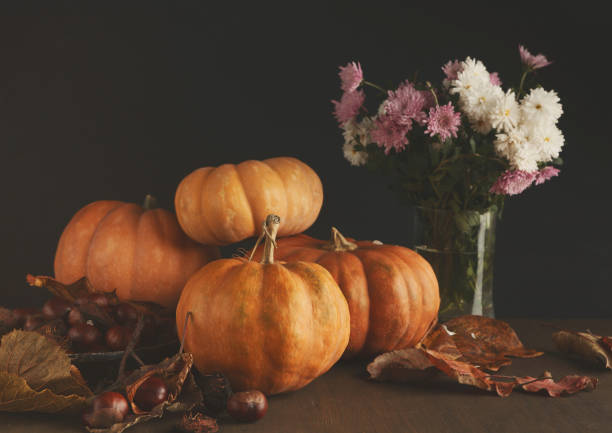 istock Beautiful pumpkins with leaves and chestnuts on black background 1022307660