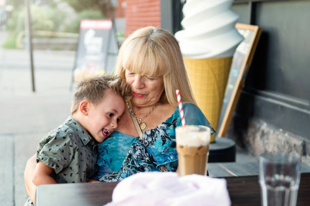 Tender moment between grandmother and grandson at ice cream parlor.