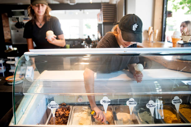 service à la clientèle dans le salon de glaces artisanales. - ice cream parlor photos et images de collection