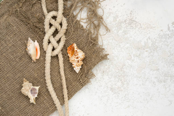 istock sackcloth and seashells with rope knot top view with copy space, nautical vacations conceptual background 1022329068