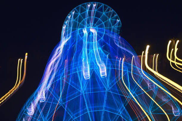 istock Lubricated when moving the camera on a long exposure illuminated by bright colors, the Ferris wheel in the park creates different varints of lines of light and colors for the background and patterns 1022337074