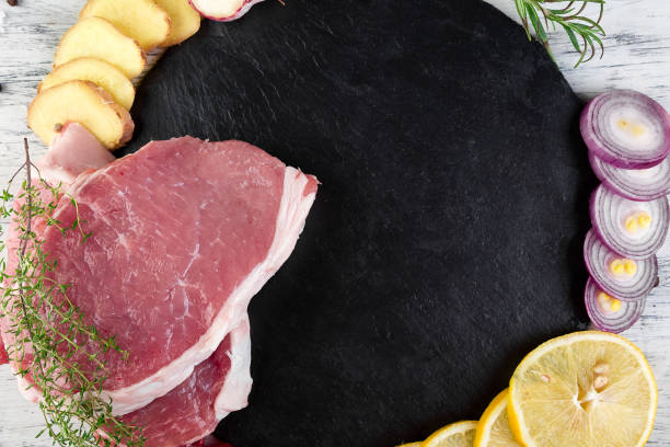 carne de porco crua na chapa ardósia preta com ingrediente do tempero - sirloin steak top sirloin onion food state - fotografias e filmes do acervo