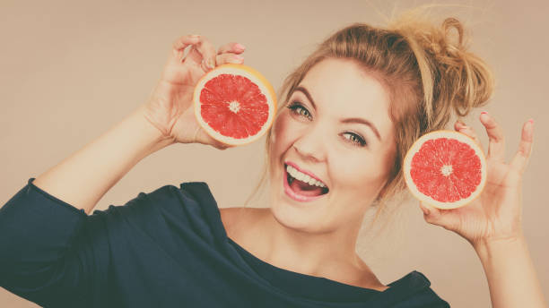 istock Happy smiling woman holding red grapefruit 1022337582