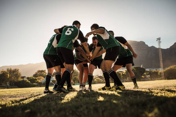 Rugby players cheering and celebrating win Rugby team putting their hands together after victory. Rugby players cheering and celebrating win. team sport stock pictures, royalty-free photos & images