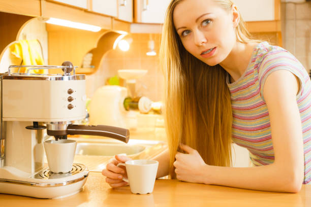 istock Woman in kitchen making coffee from machine 1022344790