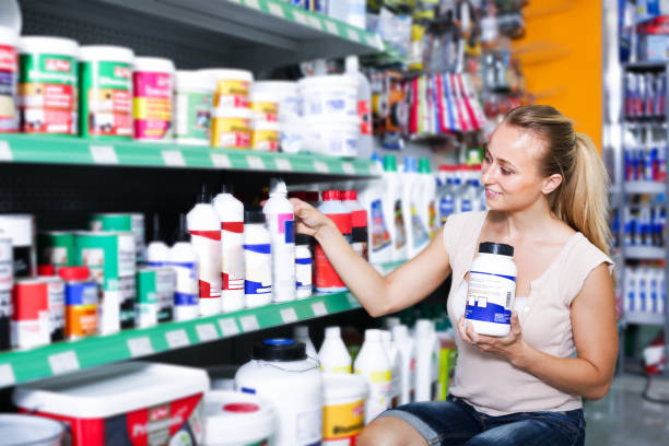 istock smiling young woman customer choosing paint medium in bottle in hypermarket 1022347554