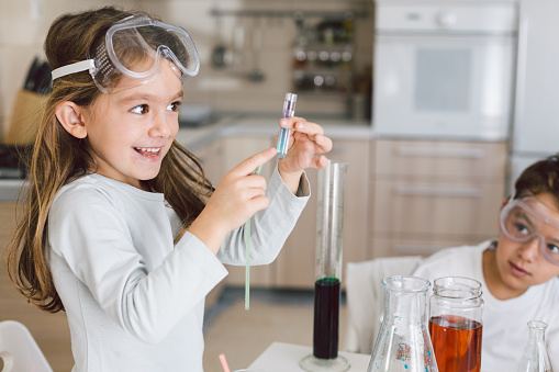 Curious children making experiments in the kitchen